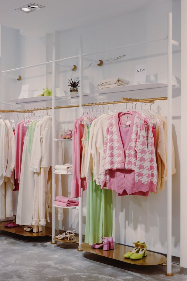 pink and white long sleeve shirt hanging on gold and white clothing rack