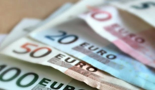 Various euro banknotes including 100, 50, 20, and 10 euro notes on a table.